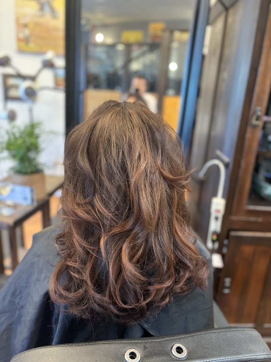 Curly blowout with warm highlights — salon styling